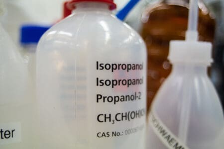 An empty plastic bottle with the words "Isopropanol" on them